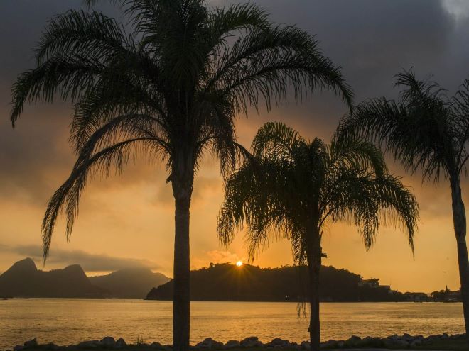 Praia do Aterro do Flamengo com seus coqueiros e pôr do sol ao fundo