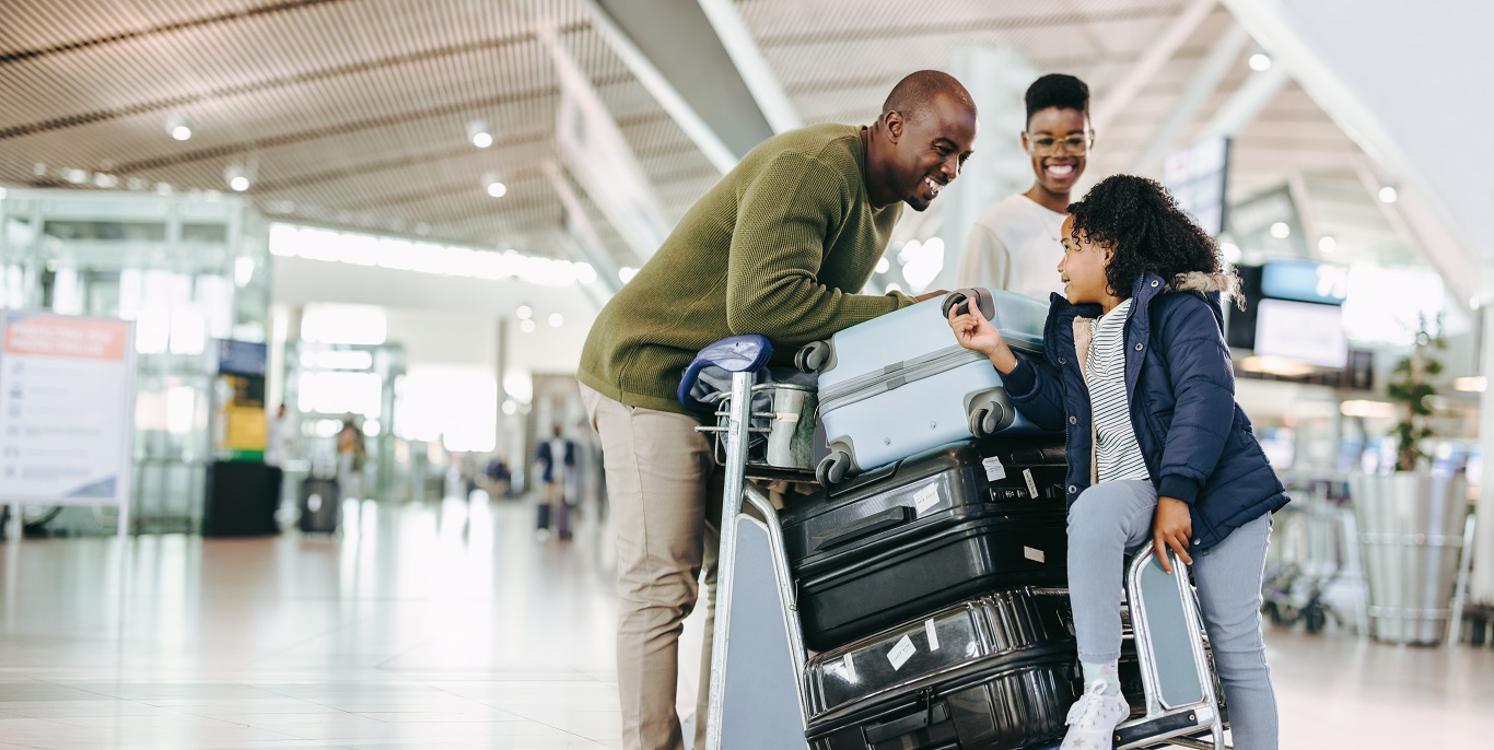 Família no terminal do aeroporto com malas de viagem e bagagens de bordo