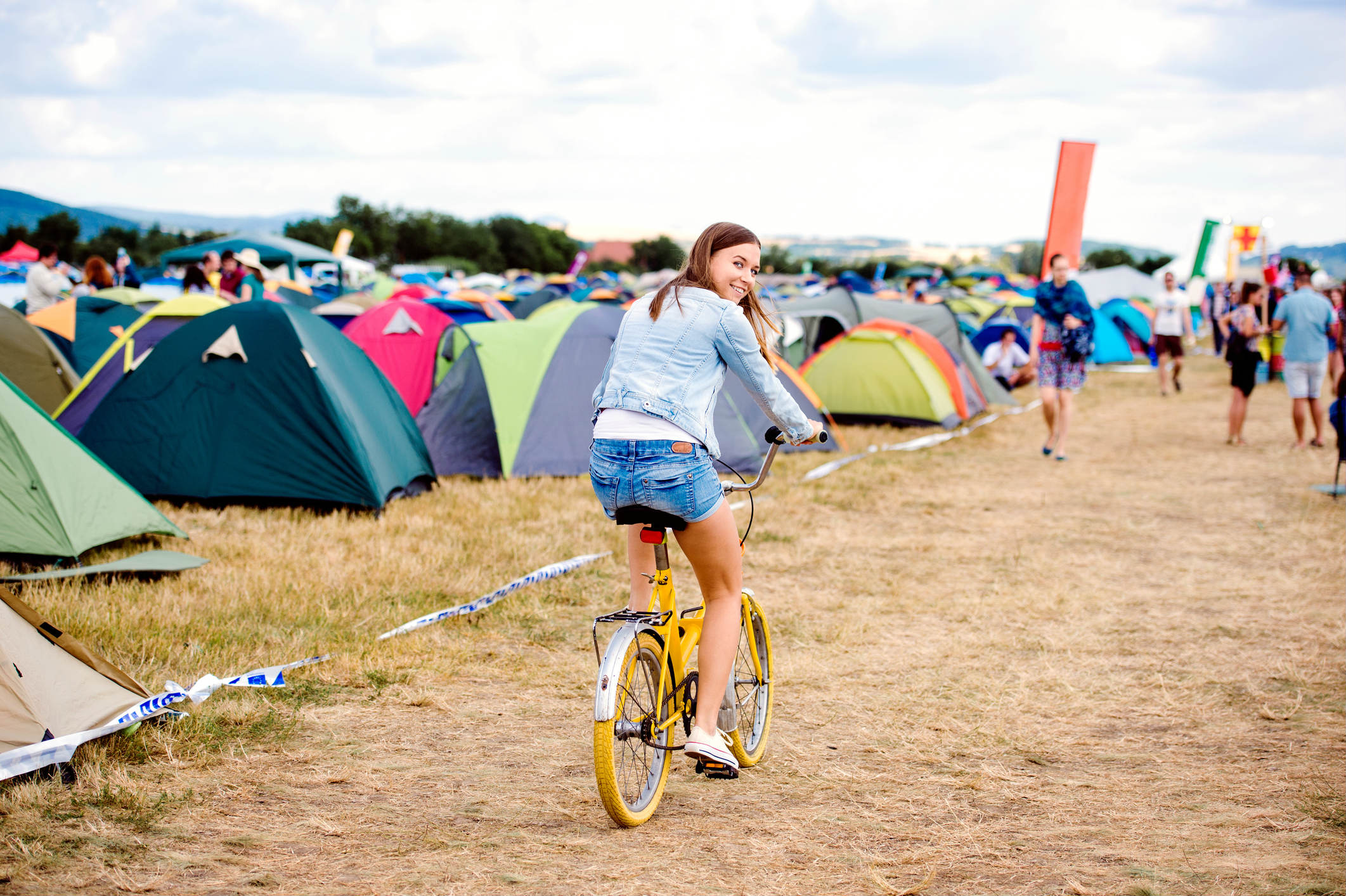 Mädchen mit Fahrrad auf einem Festival-Campingplatz