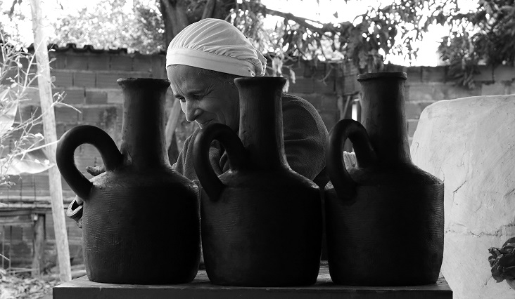 Mulher pintando peça de cerâmica